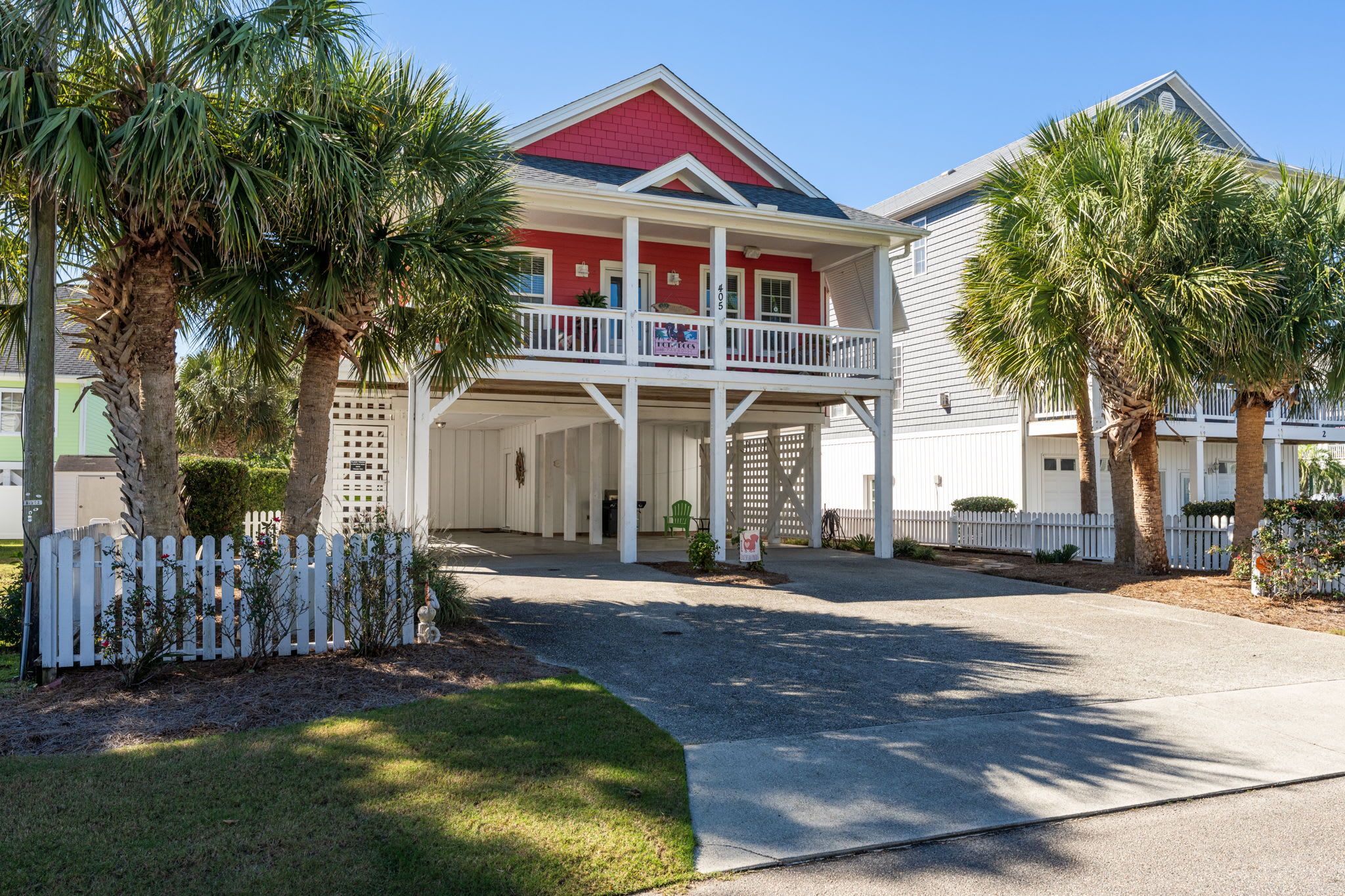 A two-story house with a red roof, white exterior, and a balcony.