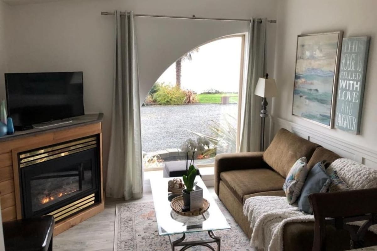 Un salon avec une cheminée, un canapé, une table basse et un téléviseur.