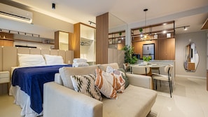 A modern hotel room with a bed, a sofa, a dining area, and a kitchen. - Skylux Downtown Rio With Rooftop Pool, Coworking Space, Gym, and Easy Access to the Subway by Carpediem (Rio de Janeiro)
