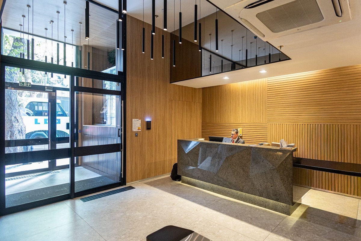 A reception area with a wooden panel wall, a reception desk, and a glass door entrance.