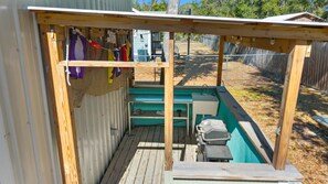 A wooden deck with a covered area, a grill, and a fenced yard. - Fin & Feather - Steinhatchee Florida (Steinhatchee)