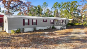 A single-story mobile home with a porch and a small staircase leading to the entrance. - Kings Creek Fish Camp - Steinhatchee Florida (Steinhatchee)