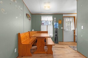 Een kamer met een houten bankje, een waterkraan en een raam met gordijnen.