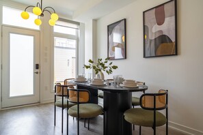 A dining area with a round table, chairs, and a potted plant.