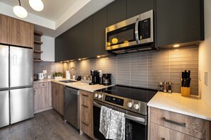 A modern kitchen with stainless steel appliances, a built-in oven, and a microwave.