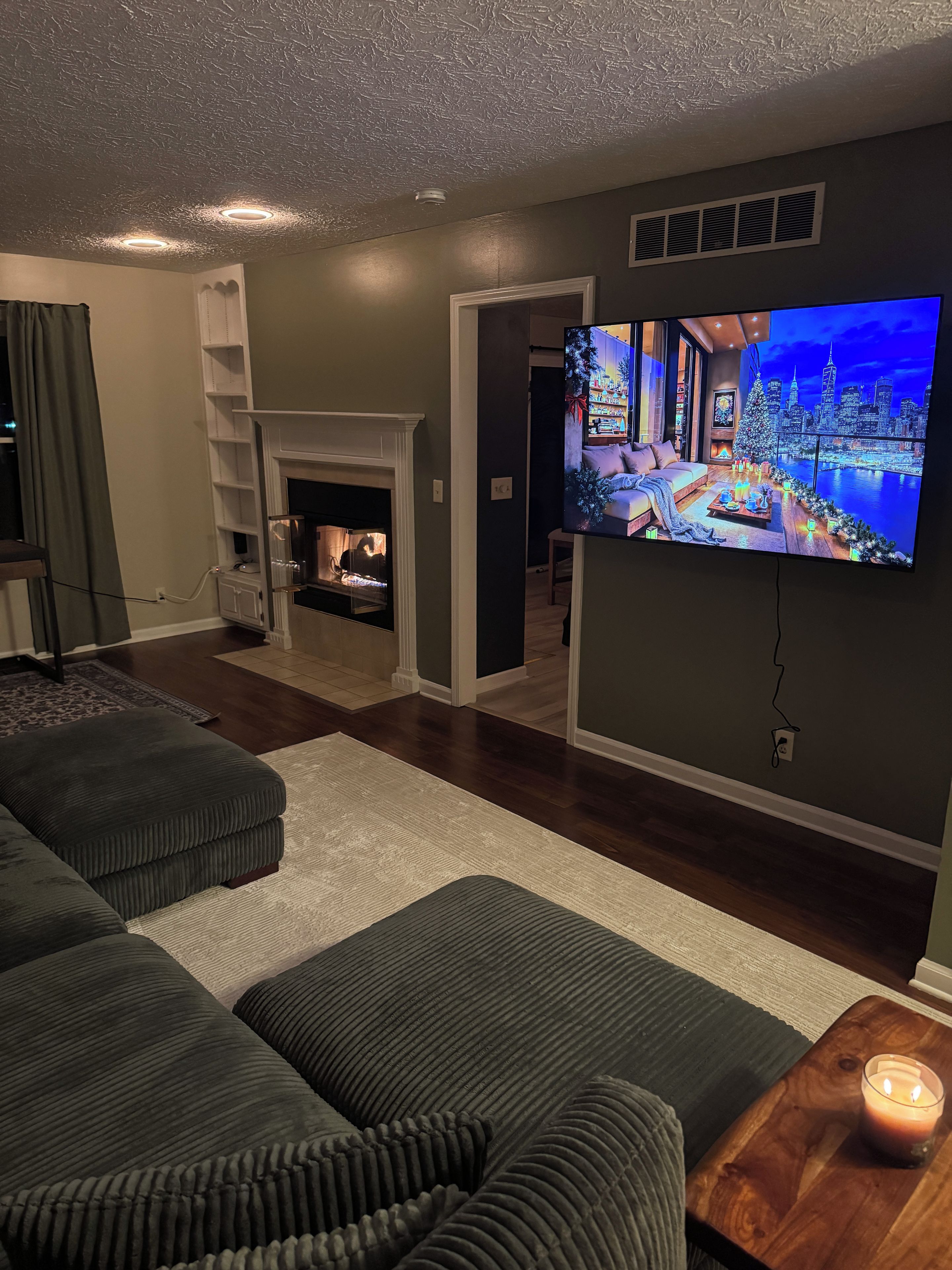 Ein Wohnzimmer mit Kamin, Flachbildfernseher und einer gemütlichen Sitzecke.