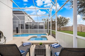 A covered outdoor swimming pool area with lounge chairs and a hot tub. - 6BR Championsgate Villa Near Disney! (Davenport)