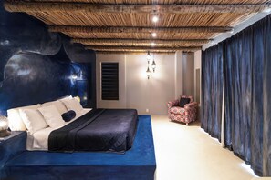 A bedroom with a large bed, a chair, a window with blinds, and a ceiling with a woven design. - New Listing (Tibau do Sul)