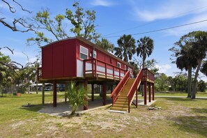 A red building with a staircase and a small balcony. - Seabreeze Cottage - Home in Steinhatchee Florida (Steinhatchee)