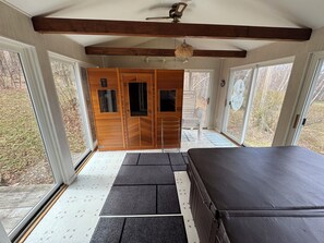 A room with a large bed, wooden wardrobe, and a bench. There are large windows and a ceiling fan. - Cozy Ski Mountain House (Wardsboro)