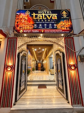 A hotel entrance with a signboard, a phone number, and a staircase leading inside. - Hotel Tatva Kashi (Varanasi)