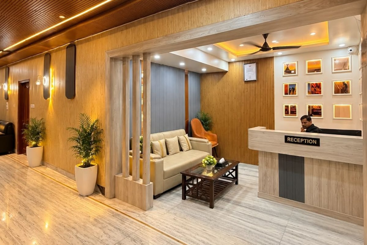 A reception area with a reception desk, a sofa, a coffee table, and potted plants.