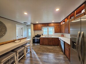 A kitchen with wooden cabinets, stainless steel appliances, and a white countertop.