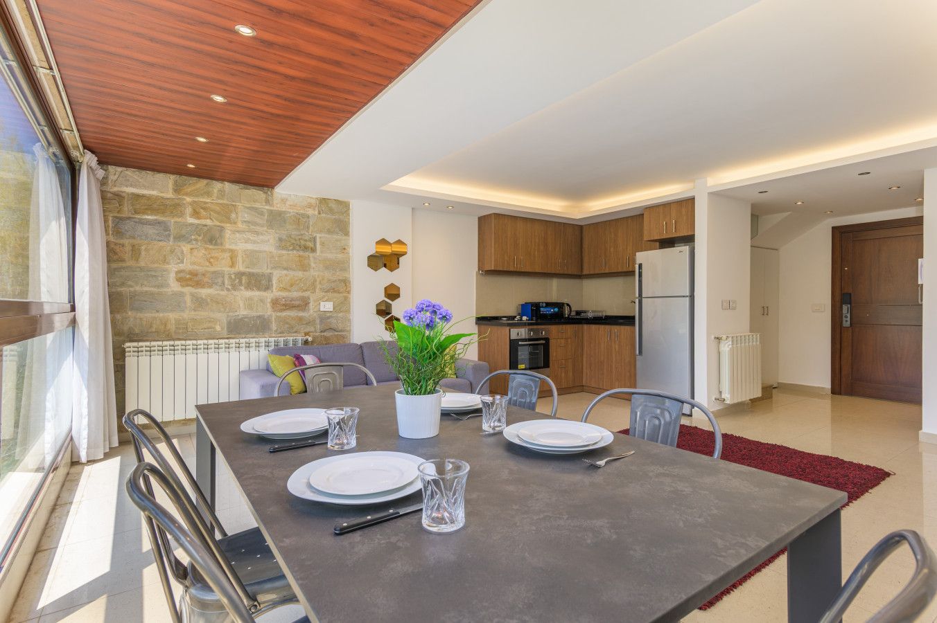 A modern kitchen with wooden cabinets, a built-in oven, and a refrigerator.
