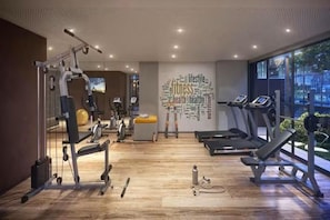 A gym with cardio equipment, weight machines, and a wall with health-related words. - New Listing (São Paulo)