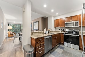 A modern kitchen with wooden cabinets, stainless steel appliances, and a large window. - Ski condo on Eagle River,  Close to BC & Vail (Avon)
