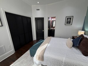 A bedroom with a bed, a closet, a door, and a wall-mounted picture. - The Mount Vernon Retreat with private yard (Lowell)