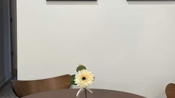 Una mesa redonda de comedor con un florero y un adorno de cuerda enrollada.