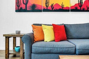 A living room with a blue sofa, three colorful pillows, a wooden side table, and a blue bowl. - Modern King 1BR/1BA Legacy Villa Near Main Pool (A) (La Quinta)