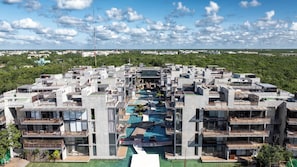 Un complex residencial modern amb diversos edificis, piscines al terrat i un pati central.