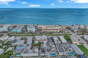 Un hotel costero con varias edificaciones, una playa y vista al océano.