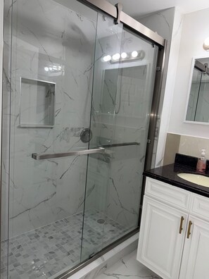 A modern bathroom with a glass-enclosed shower, a white vanity with a black countertop, and a mirror above the sink. - 3 Bd 2 Ba Apt Chinatown (Philadelphia)