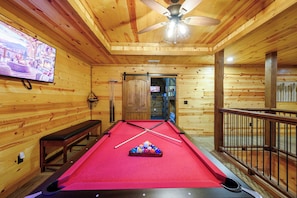 A pool table with balls, a television on the wall, and a ceiling fan. - 4 Bedroom Cabin neighboring a main entrance to Beavers Bend State Park (Broken Bow)
