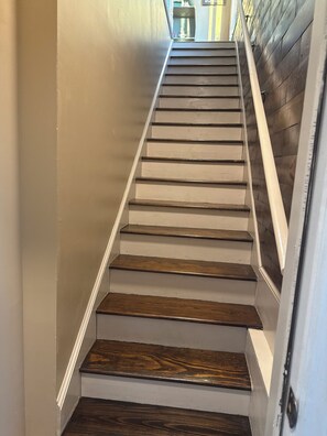 A staircase with wooden steps and white walls. - Lake Murray Retreat , Fire Pit & Boat Ramp,1 Bedroom Loft (Chapin)