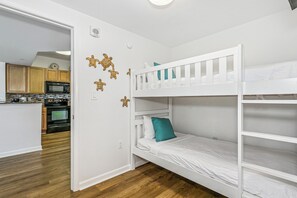 A compact room with a bunk bed, a kitchenette, and a wooden floor. - Escape to The Palms | Gulf Views, Resort Pool & Beach Gear (Destin)