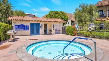 A swimming pool with a lifeguard stand and a building with a blue door in the background.