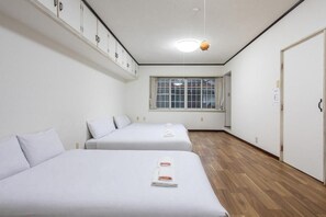 A hotel room with two beds, a window, and a wooden floor. - Akatsuki Yado Tatsumikita (Osaka, Ikuno-ku)