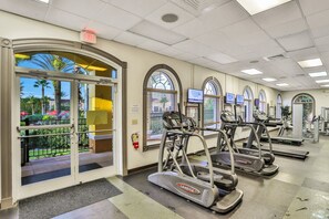 A fitness center with treadmills, a fire extinguisher, and a view of the outdoors. - 4 BR Regal Palms Haven Near Disney & Golf (Davenport)