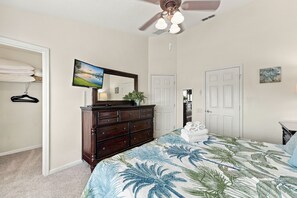 A bedroom with a bed, dresser, and a ceiling fan. - 3BR Tropical Escape With Private Pool (Kissimmee)