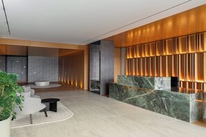 A modern reception area with a marble reception desk, seating area, and a plant. - Savoy Luxe - Luxury 3-bed w/ pool (Funchal)