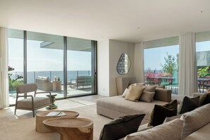 A modern living room with a large sliding glass door leading to a balcony with a view of the sea. - Savoy Luxe - Luxury 3-bed w/ pool (Funchal)