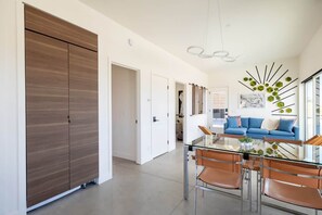 Et moderne interiør med et spiseområde, en blå sofa og en stor garderobe.