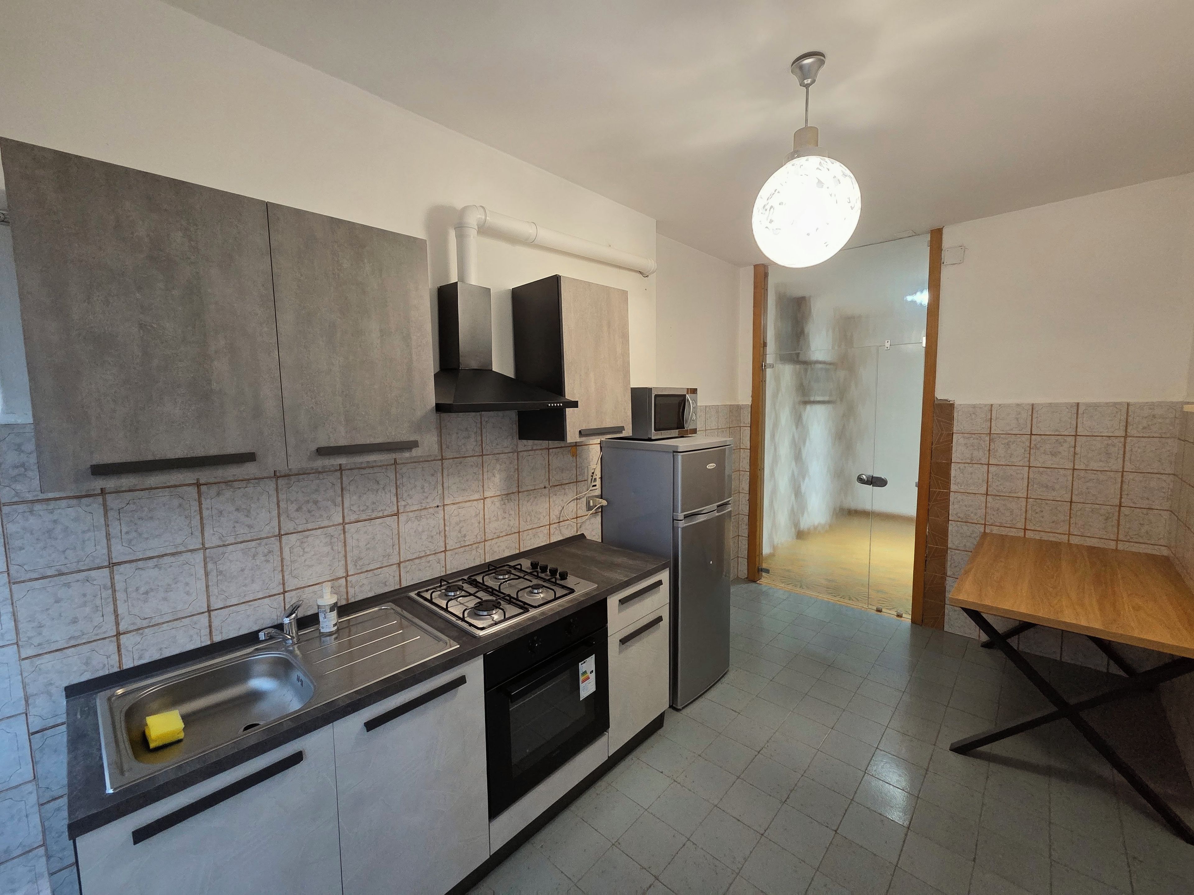 Eine moderne Küche mit Gasherd, Backofen, Mikrowelle und einem kleinen Kühlschrank.
