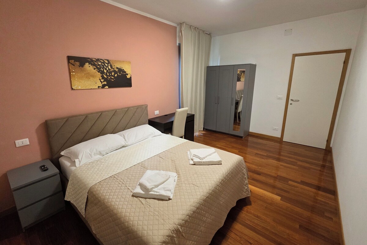 Ein Schlafzimmer mit Bett, Nachttisch, Kleiderschrank und einem Bild an der Wand.