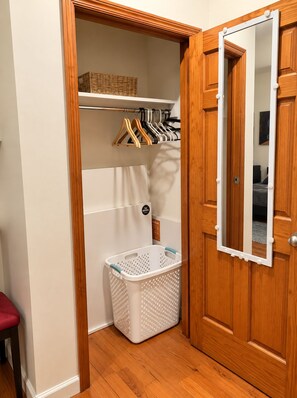 A wooden wardrobe with a mirror, a hanging rack with clothes, and a laundry basket. - 2-bedroom apartment in gorgeous Brooklyn with AC and comfort (Brooklyn)