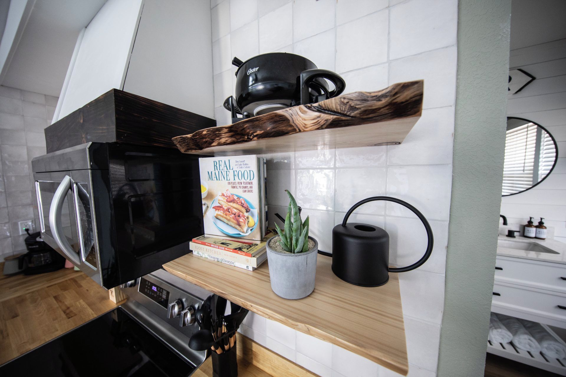 Une cuisine équipée d’un four à micro-ondes, d’une machine à café, d’un livre de recettes et d’une plante en pot.