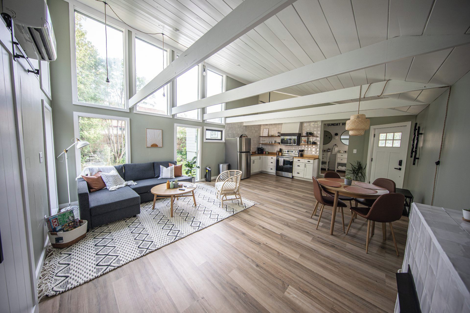 A spacious living area with a sofa, coffee table, and dining table set.