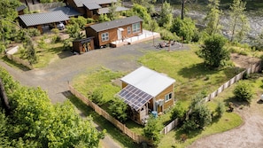 En bostadsfastighet med ett fristående hus, ett garage med tak och en installation av solpaneler.