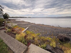 A rocky shoreline with a view of the water and distant land. - 3BR lakefront dog friendly home w/ views and kayaks (Colchester)