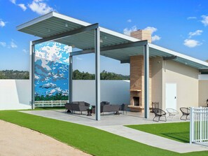 Eine moderne Außenpatio mit Glasverkleidung, Gartenmöbeln und einem Wandgemälde.
