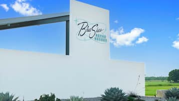 Een modern gebouw met een bord waarop 'Blue Skies RETRO RESORT' staat.