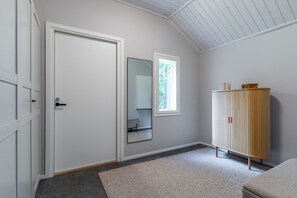 A hallway with a white door, a mirror, a window, and a wooden cabinet. - Nordic apartment IV near SCV (Rovaniemi)