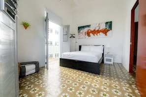 A bedroom with a bed, bedside table, and a painting on the wall. - Nando's Place 3 - Charming 1BR Apt near Old San Juan and Beach (San Juan)