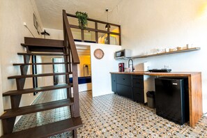 A compact kitchen with a wooden counter, a black refrigerator, and a microwave. - Elokut Loft 5 - Steps from Old San Juan and Escambron Beach (San Juan)