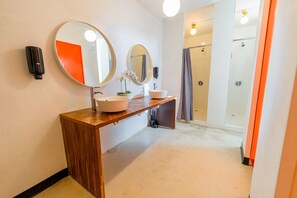 A modern bathroom with two sinks, a wooden vanity, and a shower area. - Juliette Hostel, Bed in 8-Bed Female Dorm, Old San Juan (San Juan)