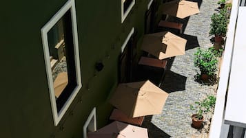 Une cour avec des espaces aménagés pour s’asseoir à l’extérieur et des plantes en pot.